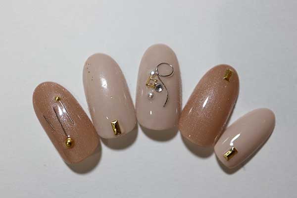 Nail art σε nude απόχρωση με χρυσές διακοσμητικές λεπτομέρειες